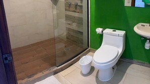 A bathroom with a glass shower enclosure, a toilet, a sink, and a green wall. - Amaizing Place in Sayulita (Sayulita)