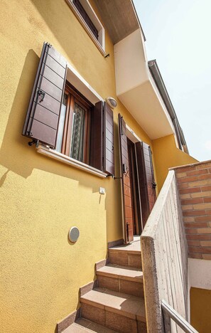 A staircase leading to a door with a window above it. - Holiday apartment with pool (Rosolina Mare)