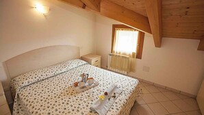 Ein Schlafzimmer mit einem Bett, einem Nachttisch und einem Fenster mit Vorhängen.