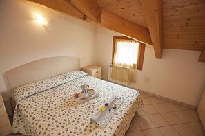 Ein Schlafzimmer mit einem Bett, einem Nachttisch und einem Fenster mit Vorhängen.