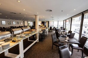 A modern hotel dining area with buffet stations, dining tables, and chairs. - Relax in Style Near Shopping, Dining & Theater Spots | Onsite Rooftop Pool (Buenos Aires)
