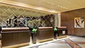 A reception area with a modern design, featuring a reception desk, a decorative partition, and a geometric patterned floor. - Rooftop Pool & Sauna | Near Florida St. & Galerías Pacífico | Pets Allowed (Buenos Aires)