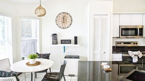 A modern kitchen with a microwave, oven, and a dining area with a table and chairs. - "SunDowner Bay Villa" (Cape Coral)