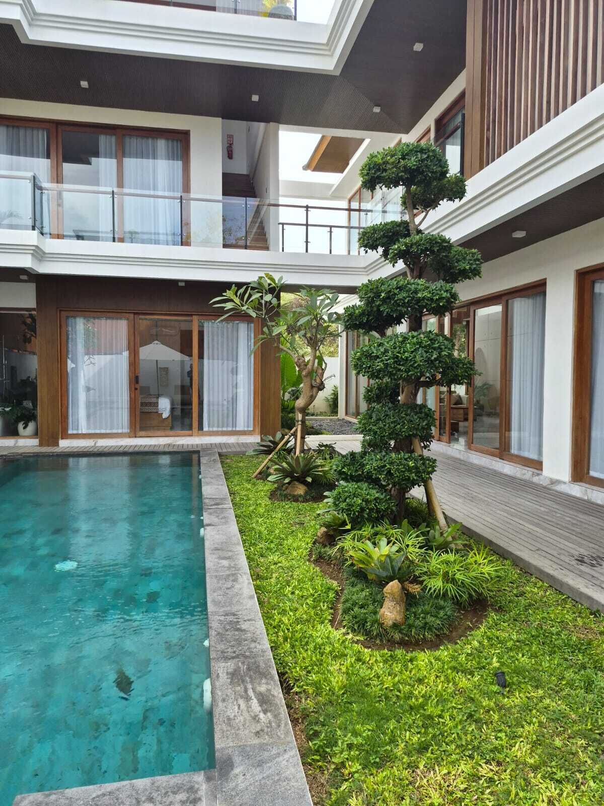 Un edificio moderno con piscina, un jardín cuidado y un balcón.