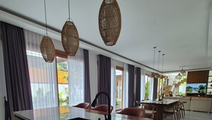 A spacious living area with a large island, dark-toned cabinetry, and a modern kitchen. - JJ Villa 7 Ocean Blue (Badung)