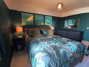 A bedroom with a bed, nightstands, a mirror, and artwork on the wall. - Bright City Centre Apartment and Stunning Views (Belfast)