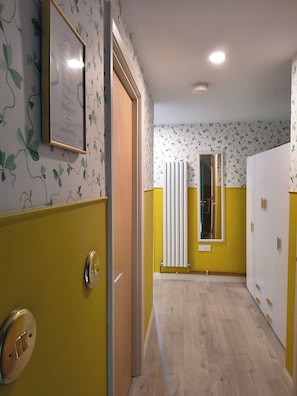 A hallway with a radiator, a door, and a framed certificate on the wall. - Bright City Centre Apartment and Stunning Views (Belfast)