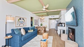 Ein modernes Wohnzimmer mit blauem Sofa, einem Esstisch und einem Kamin.