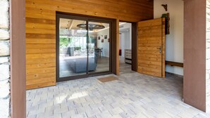 Une façade en bois avec une porte en verre donnant accès à un espace intérieur.