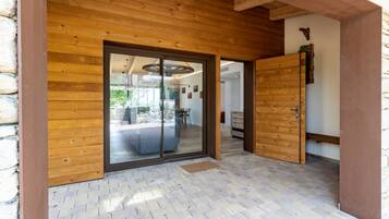A wooden exterior with a glass door leading to an interior space.