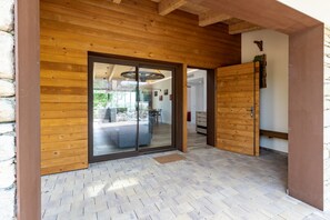 Eine Holzfassade mit einer Glastür, die zu einem Innenbereich führt.