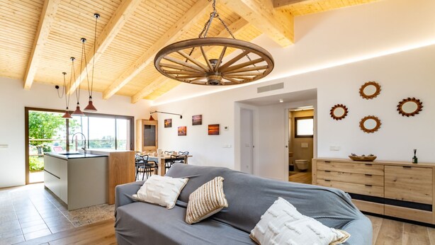 Un intérieur moderne avec un lit, un plafond en bois et un coin repas.