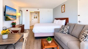 Hotellihuone, jossa on sänky, sohva, ruokapöytä ja televisio, jolla näkyy kuva kohteesta Myrtle Beach, Etelä-Carolina.