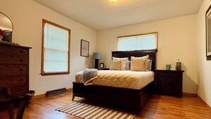A bedroom with a bed, dresser, and a radiator. - Cozy 2-bedroom house in tranquil Excelsior Springs with AC (Excelsior Springs)