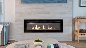 Una sala de estar moderna con chimenea, televisor montado y un diseño de mesa original.