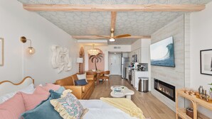 Un dormitorio moderno con cama, sofá, zona de comedor, cocina y chimenea.