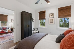 A bedroom with a bed, a desk, a chair, and a door.