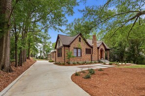 A two-story house with a brick exterior, a chimney, and a front porch.