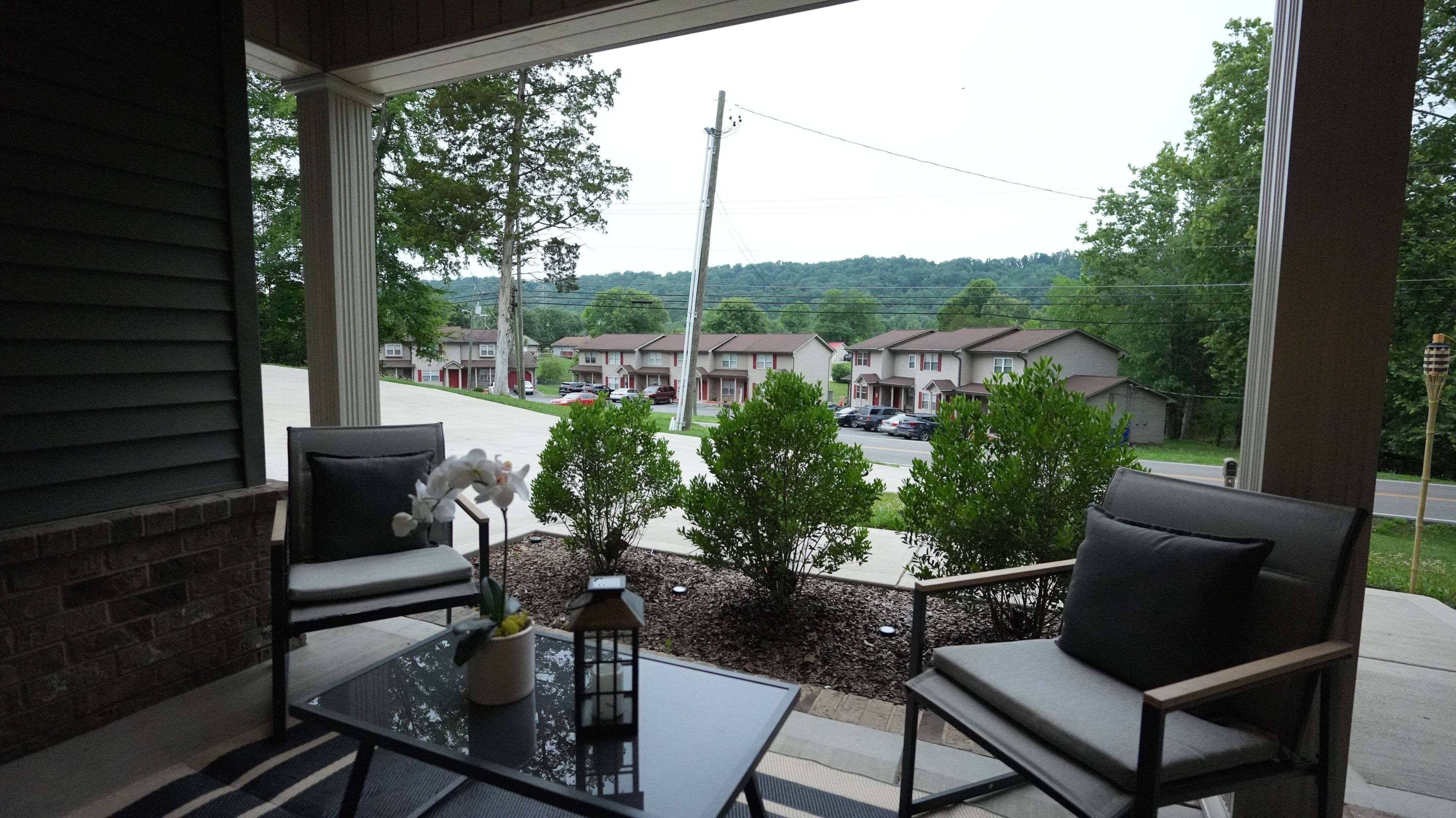 A balcony with two chairs, a small table, and a potted plant.. Knoxville Hills Family Getaway Near UT Knoxville and Downtown w. Gameroom + Yard