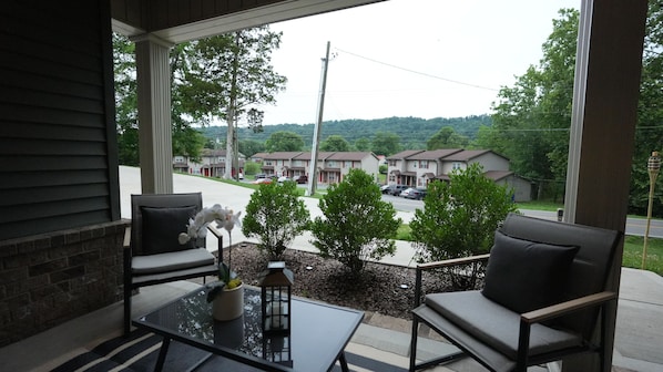 A balcony with two chairs, a small table, and a potted plant.