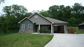 A two-story house with a garage, a front porch, and a well-maintained lawn.