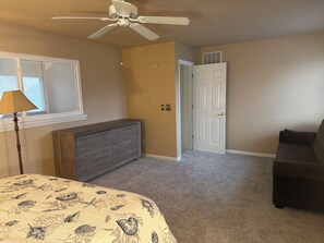 A bedroom with a bed, dresser, ceiling fan, and a door leading to another room. - Beautiful Townhouse in Lewes Parking Clean Spacious (Lewes)