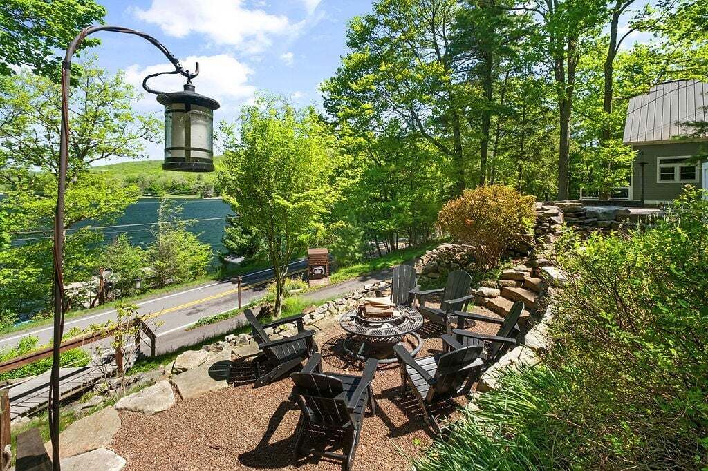 A patio with outdoor seating, a fire pit, and a lantern.