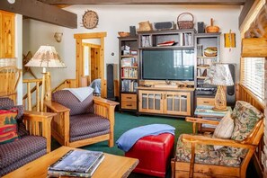 A cozy living room with a television, bookshelves, and a fireplace. - Tahoe Group Oasis | 5BR, EV Charger & Fast Wifi (Tahoma)