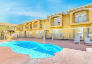 A hotel with a swimming pool, balconies, and a patio area. - Coastal three-bedroom condo near the beach, pool and park (Corpus Christi)