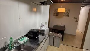 A compact kitchen with a sink, a coffee maker, and a trash bin. - GORO HOTEL (Tokyo)