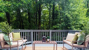 Eine Terrasse mit zwei Sofas, einem Tisch und Topfpflanzen.