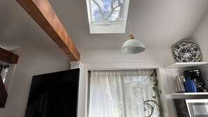 Een keuken met een dakraam, een hanglamp, een koffiezetapparaat en een decoratief bord.