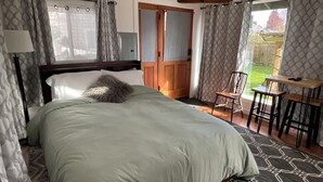 Een slaapkamer met een bed, een stoel, een tafel en uitzicht op de omgeving.