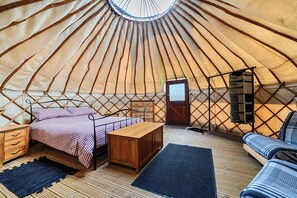 A yurt interior with a bed, wooden furniture, and a small table. - Yurt Sleeps 2 - Bbq & Fire Pit - Dogs Welcome (Bodmin)
