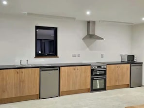 Une cuisine moderne avec des meubles en bois, un lave-vaisselle, un four Ă micro-ondes et une cuisiniĂšre.