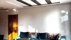 A living room with a blue sofa, a coffee table, and a wooden door.