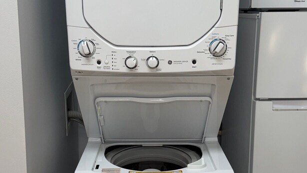 Un appareil compact combinant lave-linge et sèche-linge, à chargement frontal, doté d’une étiquette ENERGYGUIDE et d’un panneau de commande offrant de nombreuses options.