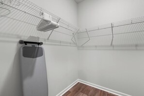A corner of a room with a metal drying rack, a white towel, and a grey mat on the floor. - Mermaid Soirée near the Beach (Myrtle Beach)
