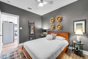 A bedroom with a bed, a nightstand, a lamp, a wall art piece, and a ceiling fan. - Hidden Lake Condos 131, walk to Gulf Place! (Santa Rosa Beach)