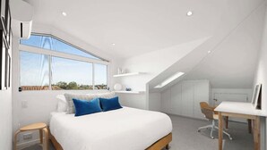 Een moderne slaapkamer met een groot bed, een bureau en uitzicht op de stad.