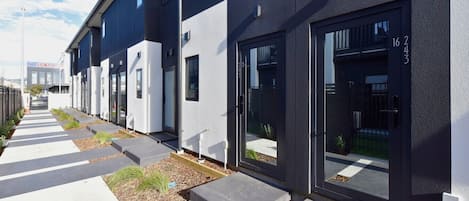 Un edificio moderno con un diseño limpio y geométrico, que presenta una serie de ventanas amplias y un exterior bien cuidado.