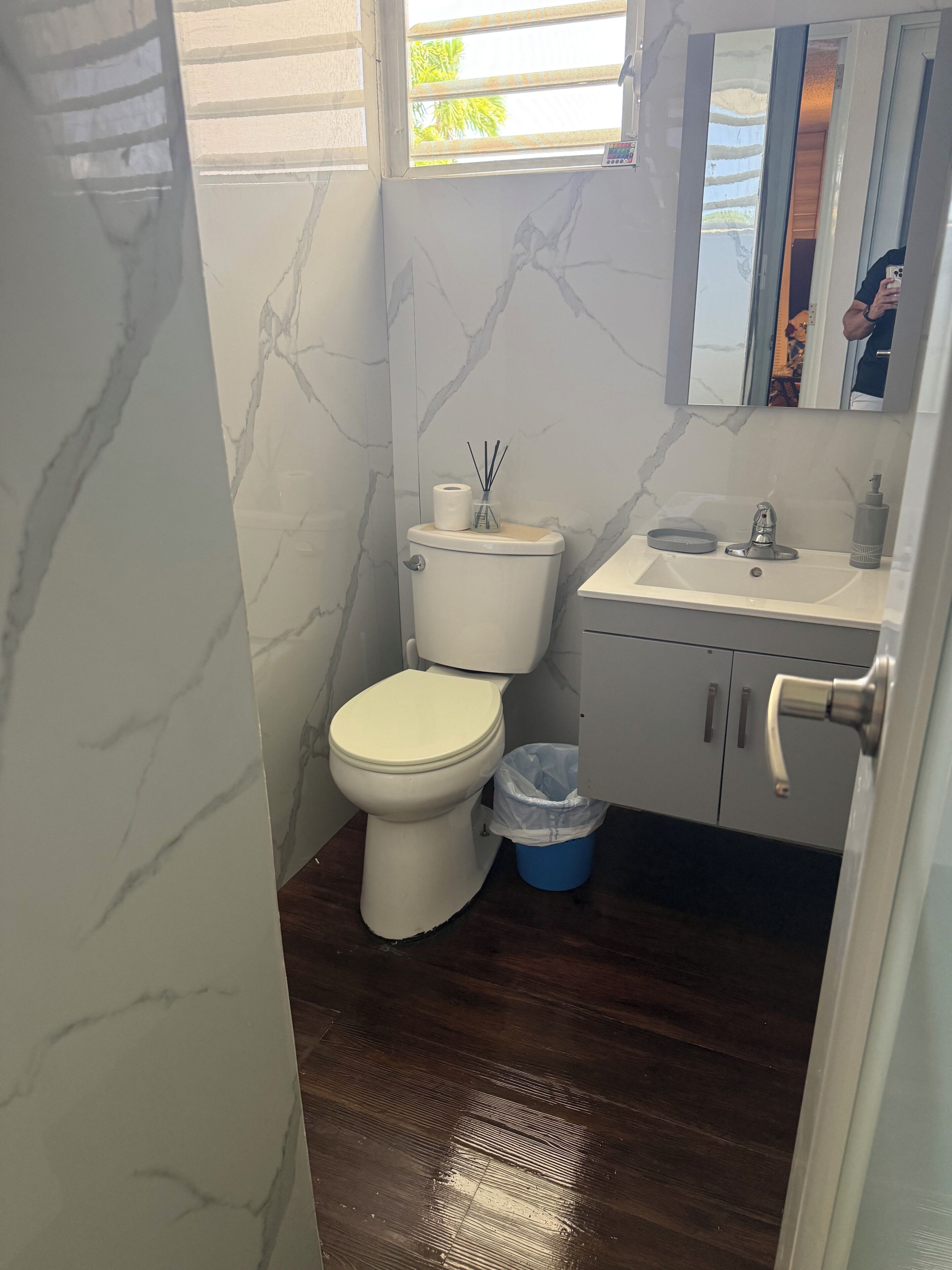 Un baño con inodoro, lavamanos y espejo.