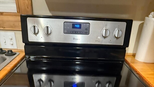 A stainless steel Whirlpool oven with a digital clock, control knobs, and a glass top. - Cottage No. 4 on Ranch with Fishing & Camping (McKinney)
