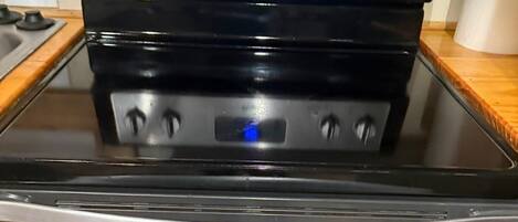Horno Whirlpool de acero inoxidable con reloj digital, perillas de control y superficie de vidrio.