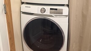 A stacked washer and dryer unit with a control panel and a door. - Cottage No. 4 on Ranch with Fishing & Camping (McKinney)