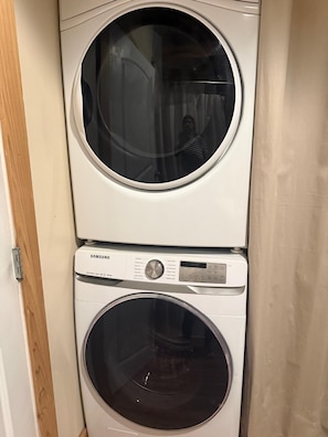 A stacked washer and dryer unit with a control panel and a door.