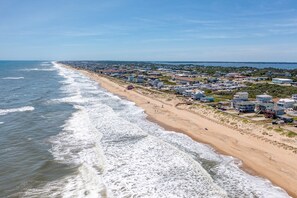 Eine Küstenstadt mit Strandhäusern, einem Sandstrand und Blick auf den Ozean.