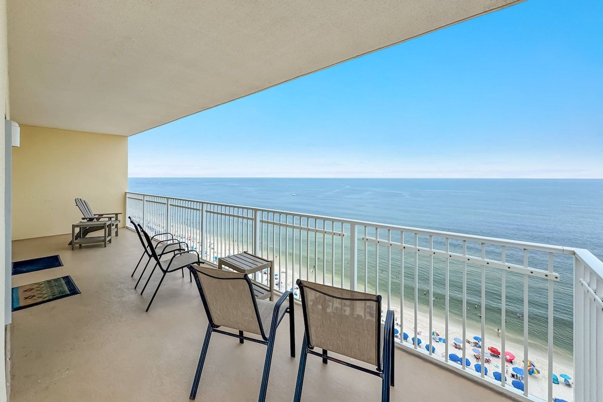 A balcony with a view of the sea, featuring a table and chairs.