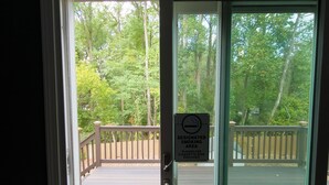 A deck with a smoking area sign, wooden railings, and a view of trees. - Beautiful 3-bedroom Serenity house in a Cul-de-Sac with AC in charming Decatur (Decatur)