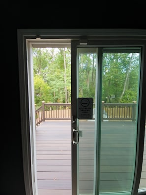 A deck with a smoking area sign, wooden railings, and a view of trees. - Beautiful 3-bedroom Serenity house in a Cul-de-Sac with AC in charming Decatur (Decatur)